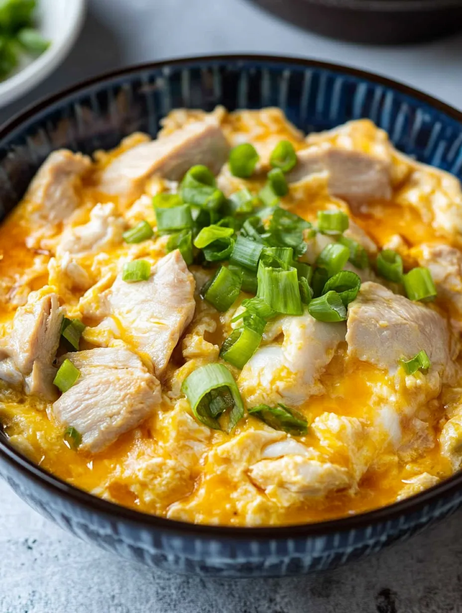 Un bol d'oyakodon, un plat japonais préparé avec du poulet et des légumes.