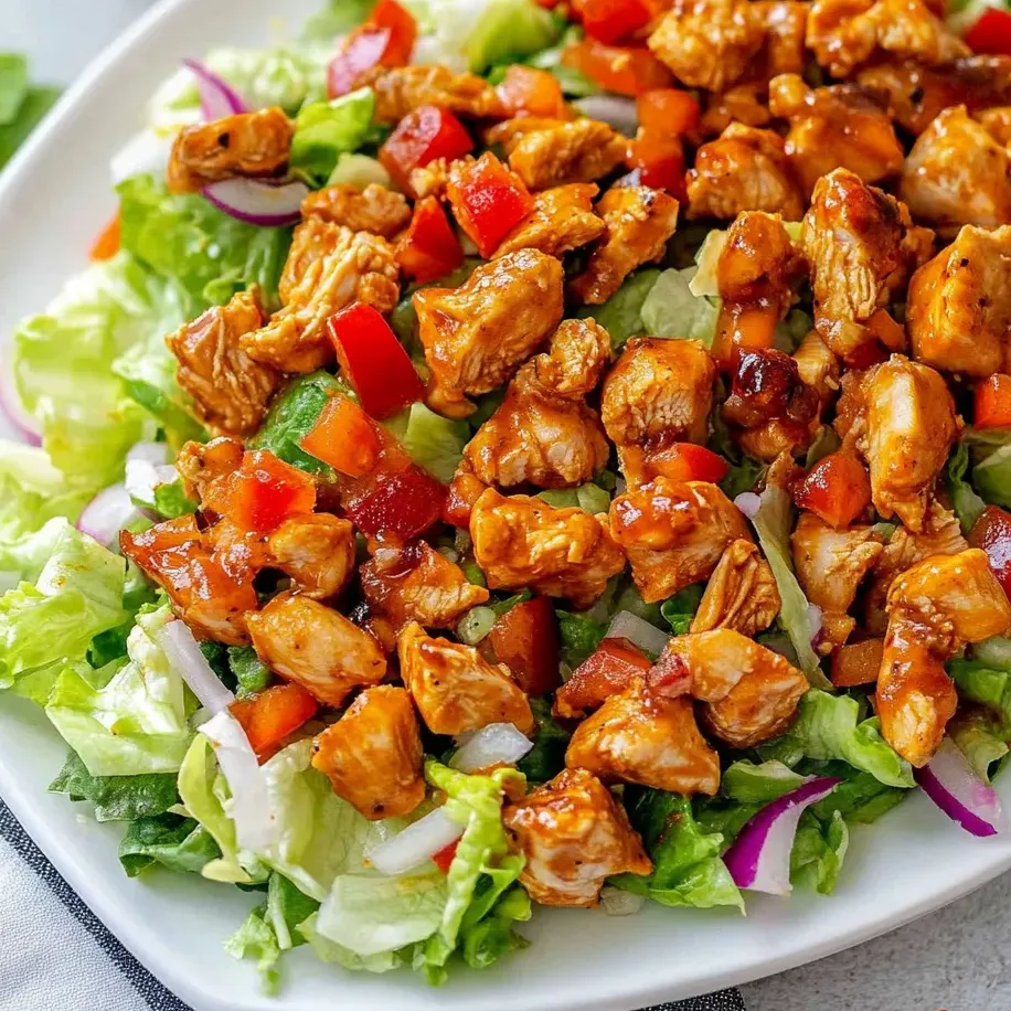 Une assiette de salade de poulet, laitue et tomates.