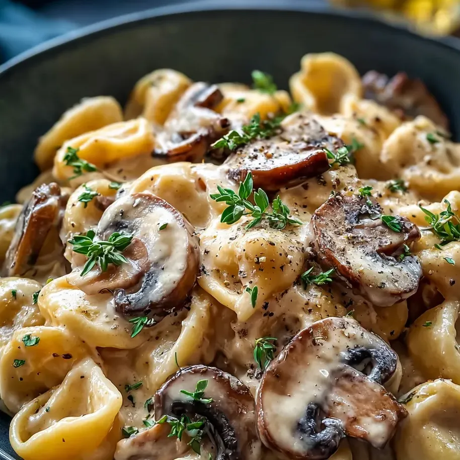 Un bol de pâtes avec des champignons frais et des herbes.