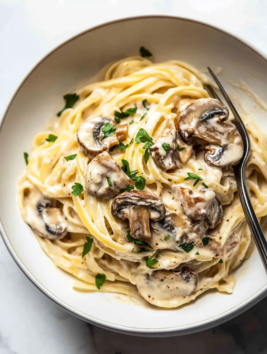 Un bol de pâtes avec des champignons et des herbes.