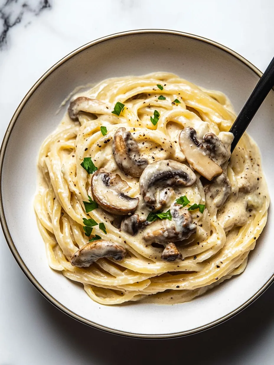 Un bol de pâtes avec des champignons et des herbes.