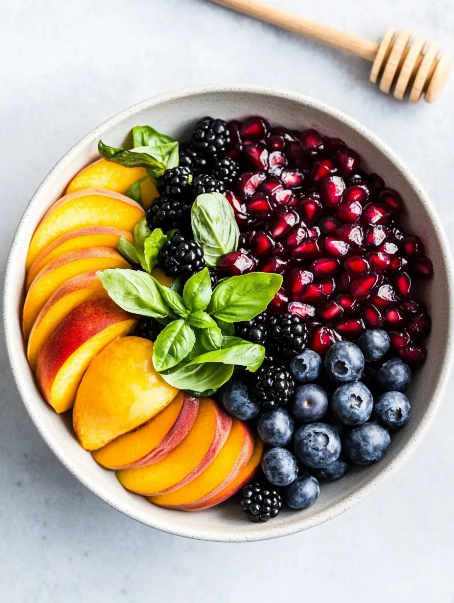 Un bol de fruits avec myrtilles, framboises, pêches et mûres.