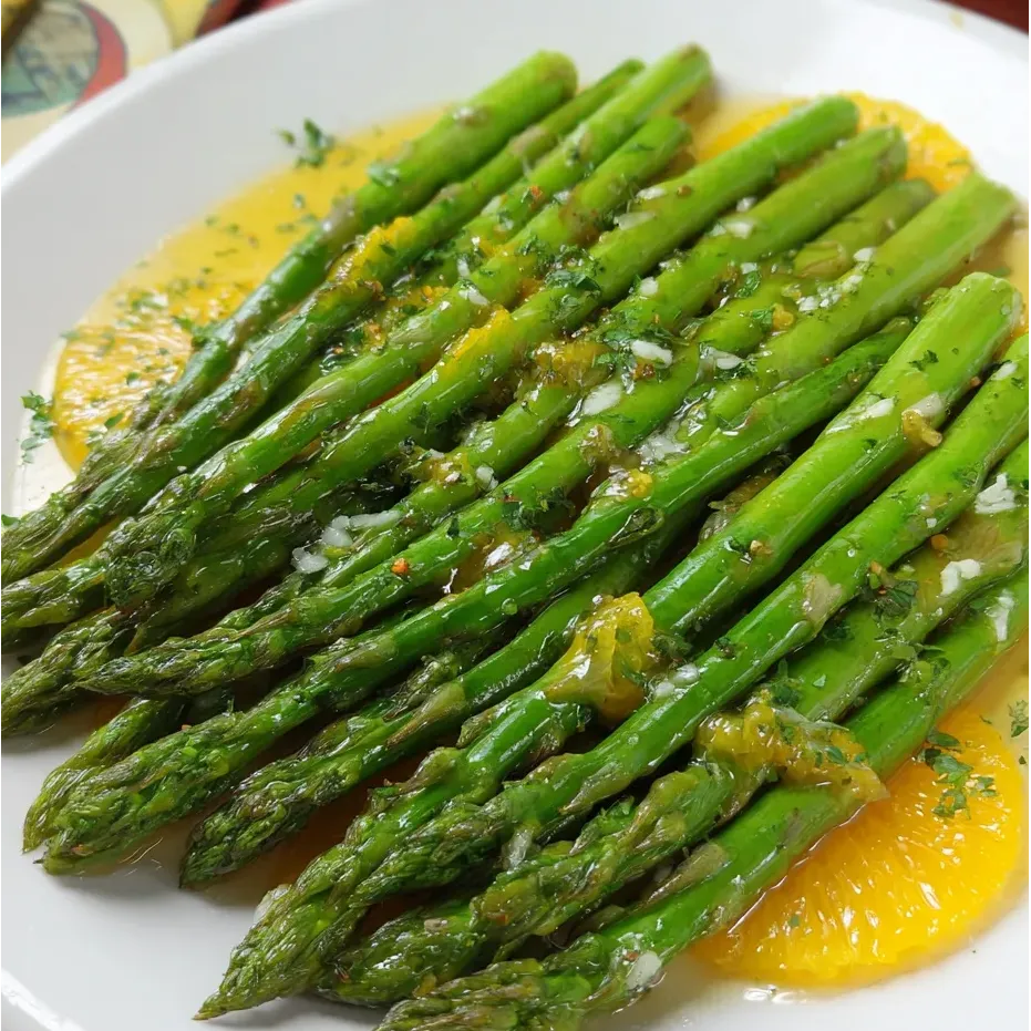 Une assiette d’asperges nappées de sauce.