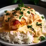 Une assiette de riz et poulet nappés de sauce crémeuse.