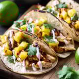 Trois tacos avec garnitures d'ananas et de poulet.