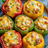 Quatre poivrons farcis avec fromage et herbes.