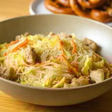 Un bol de pancit avec viande et légumes.