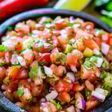 Un bol de salsa avec tomates, oignons et piments.
