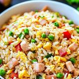 Un bol de riz avec pois verts et jambon.