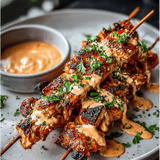 Une assiette de viande avec une sauce à tremper.