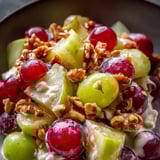Un bol rempli de fruits : raisins, pommes et noix.