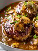 Gros plan sur un morceau de viande avec des champignons dessus.