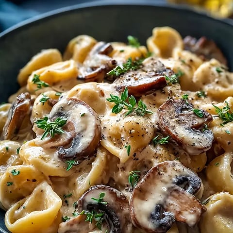 Un bol de pâtes avec des champignons frais et des herbes.
